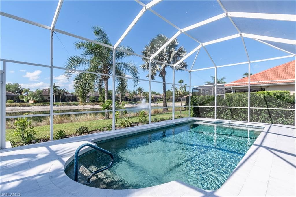 Pool featuring a lanai, a water view, and a patio area with custom marble flooring and glass tiles
