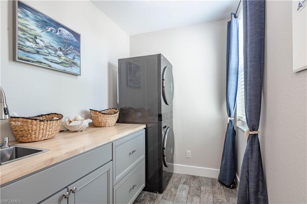 Laundry area with cabinet space, stacked washing machine and dryer