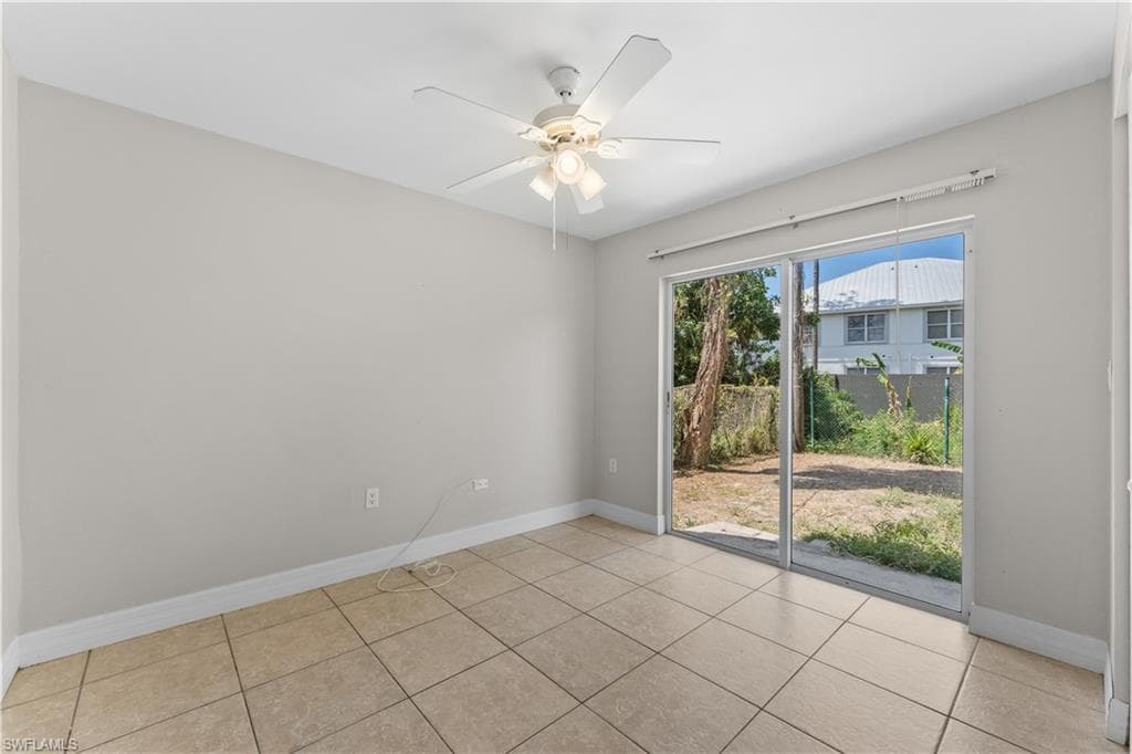 Empty room featuring baseboards, ceiling fan, and tile patterned flooring