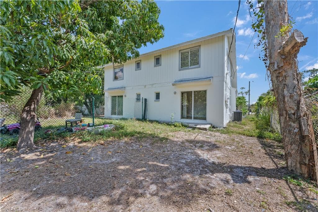 Back of property featuring cooling unit and fence