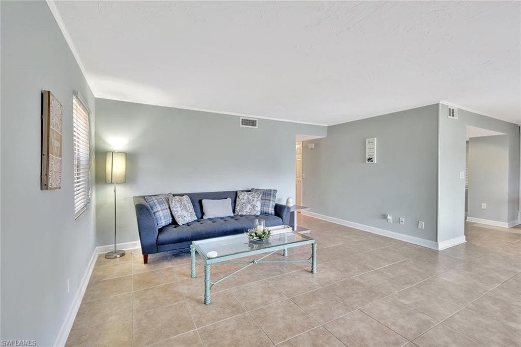 Tiled living room featuring baseboards and visible vents