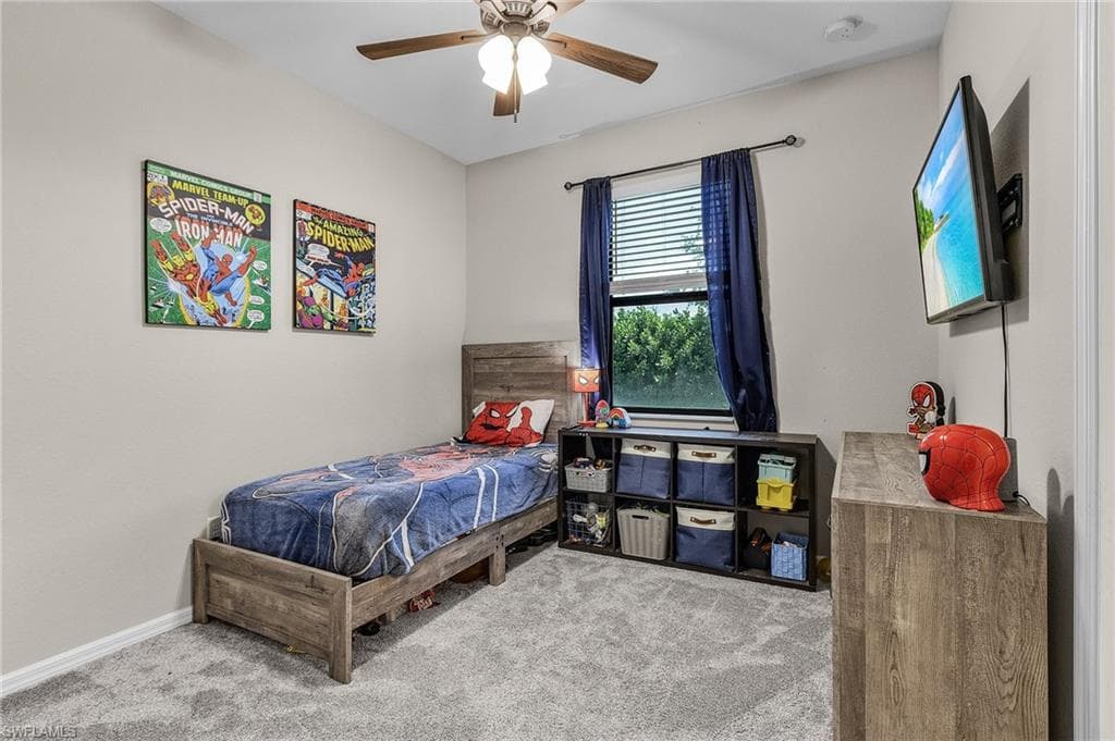 Bedroom with carpet flooring, baseboards, and a ceiling fan