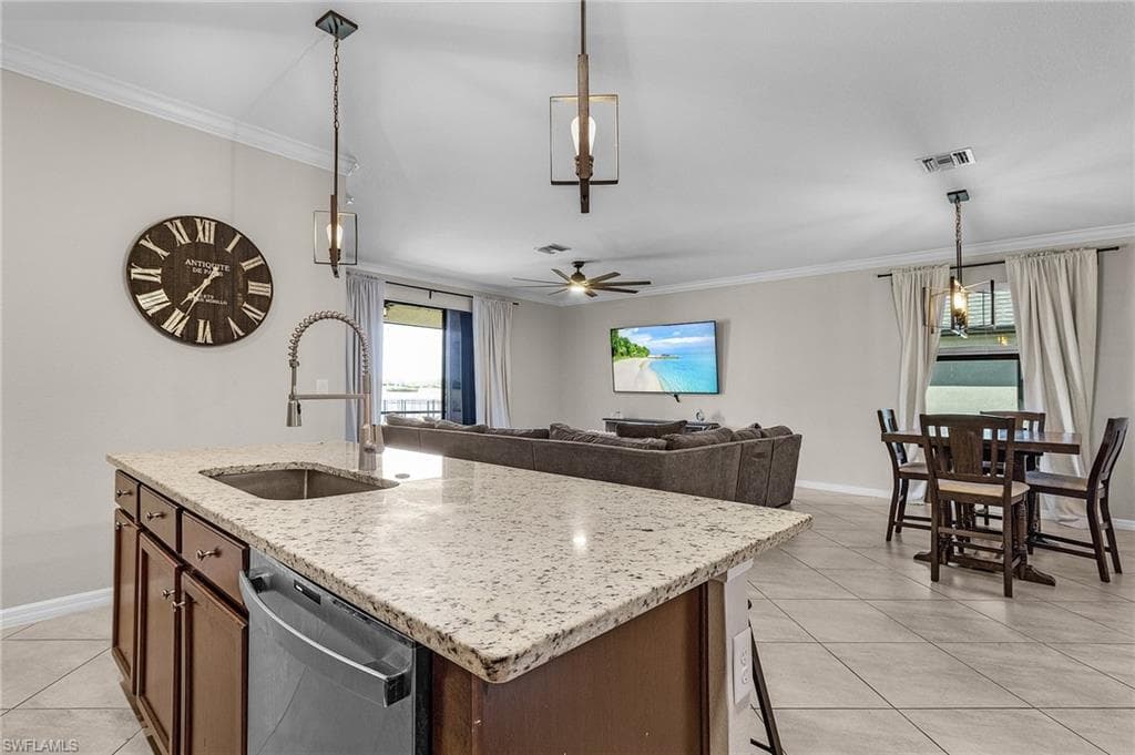 Kitchen with dishwasher, baseboards, a sink, and light tile patterned flooring