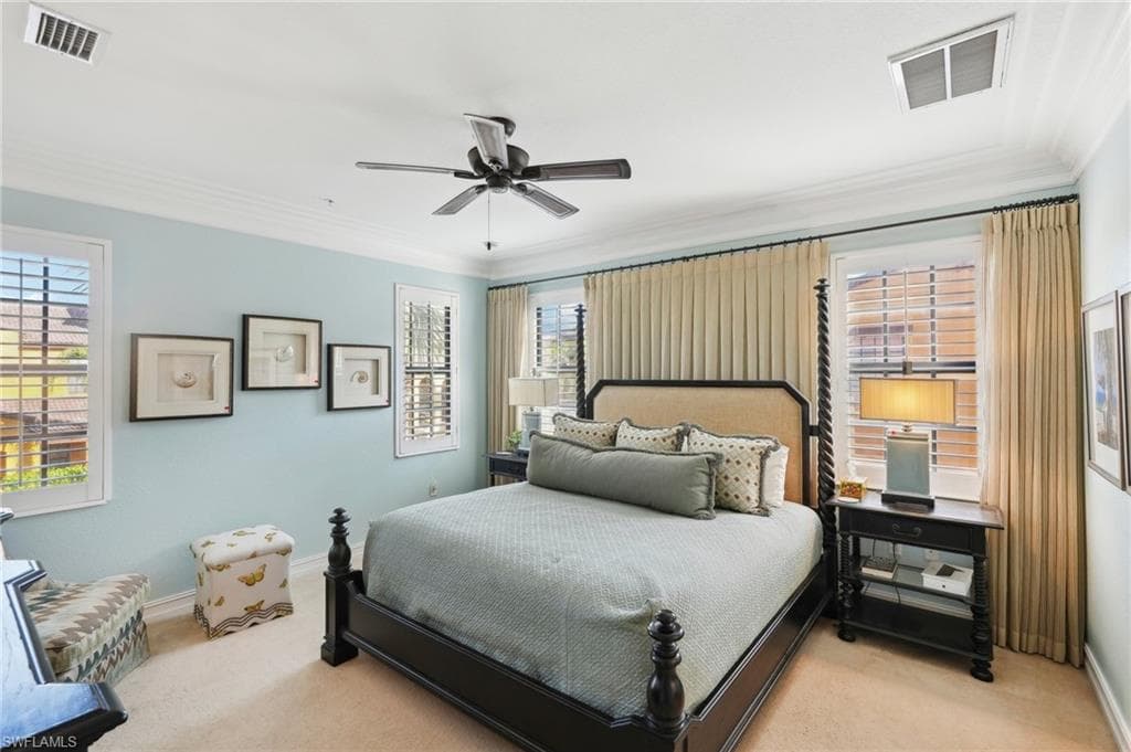 Bedroom with carpet floors, crown molding, and visible vents