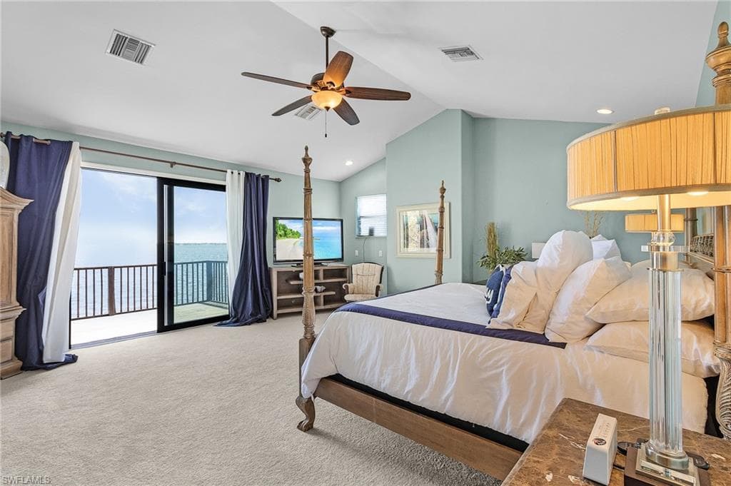 Primary upstairs ensuite bedroom , featuring new carpet , cathedral ceiling, ceiling fan, access to deck, and huge walk in closet