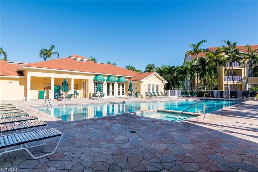 Community pool with a hot tub, a patio area, and french doors