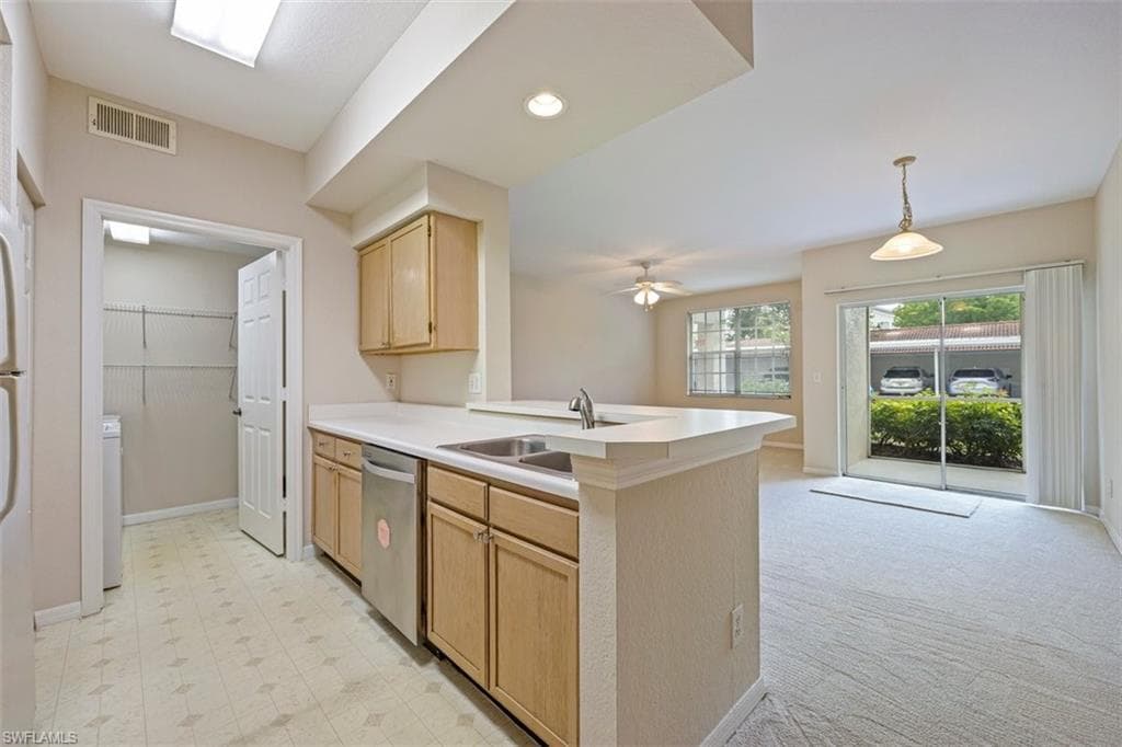 Kitchen with dishwasher, light brown cabinets, a peninsula, light countertops, and ceiling fan