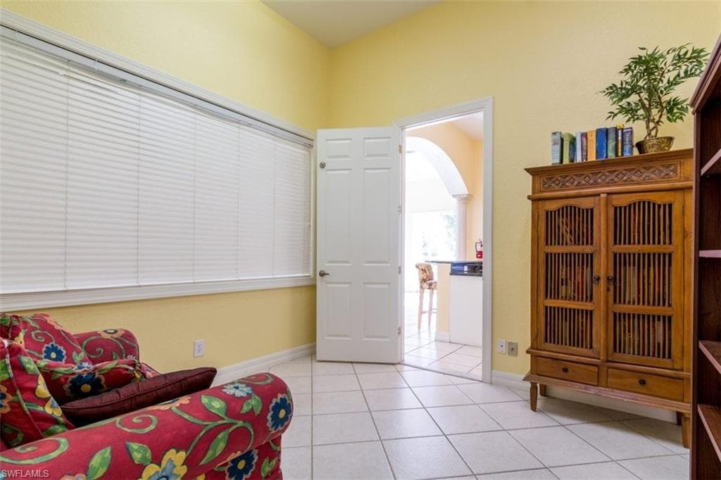 Sitting room with light tile patterned floors and arched walkways