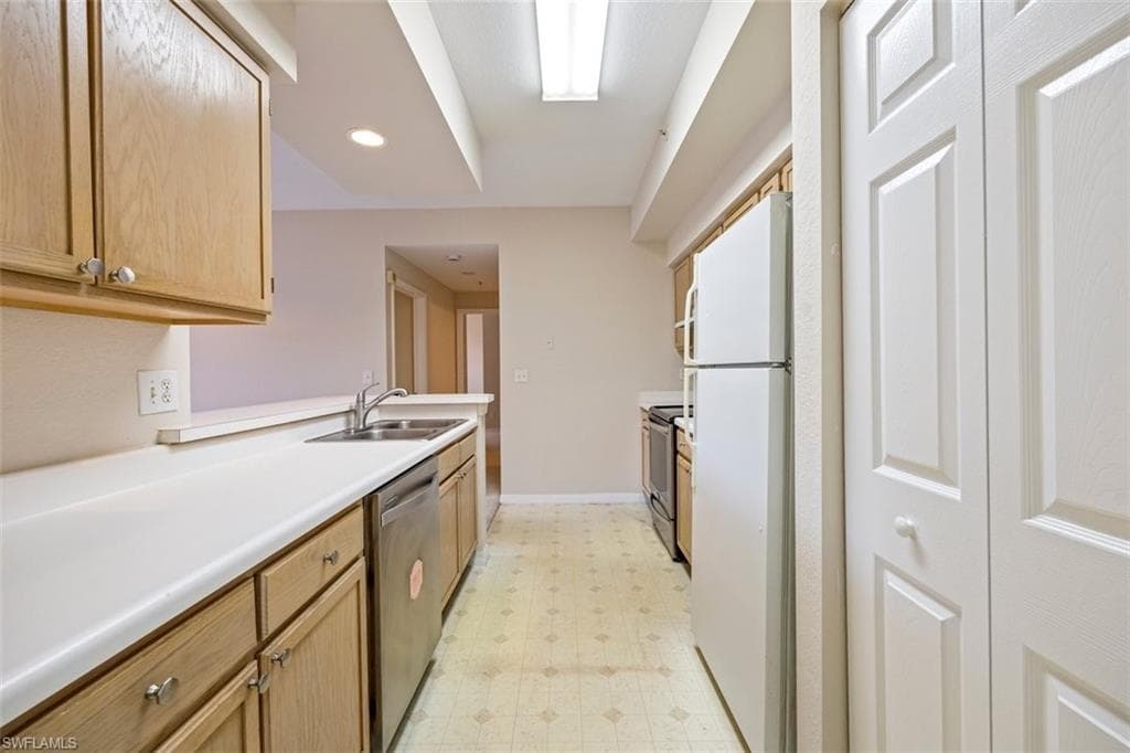 Kitchen with appliances with stainless steel finishes, light flooring, light countertops, and recessed lighting