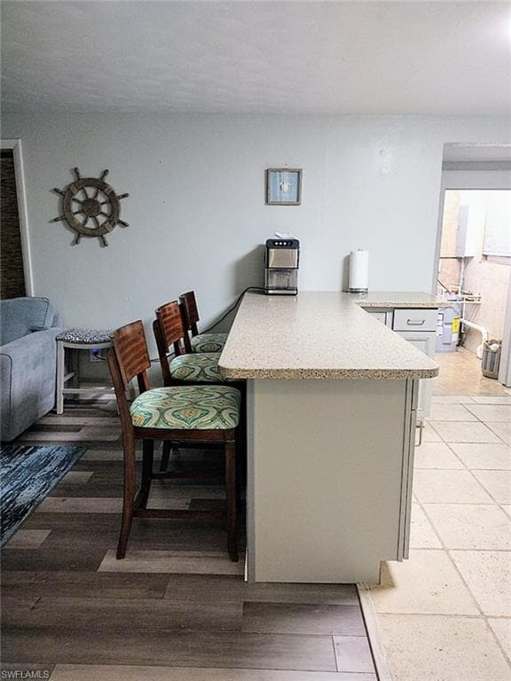 Kitchen featuring a peninsula and light stone countertops