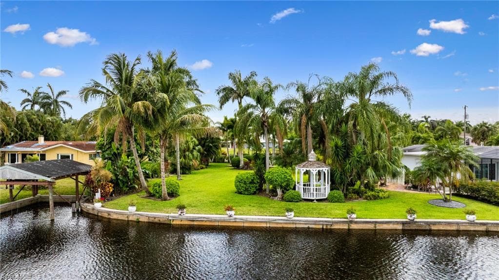 View of property's community with a gazebo, a water view, and a lawn
