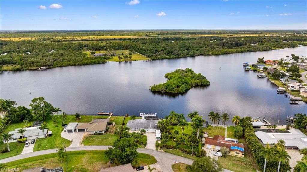 Aerial view of residential area featuring property parcel outlined and a nearby body of water