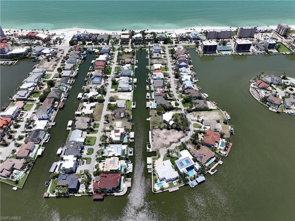 Aerial view of property and surrounding area with a nearby body of water and nearby suburban area