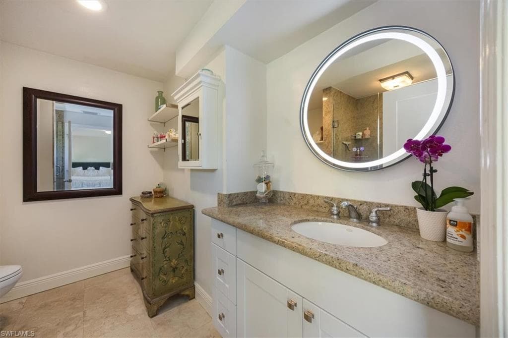 Primary bathroom has a shower granite counters and travertine floors