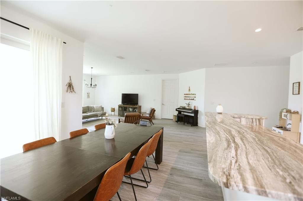 Dining area featuring a chandelier, light wood-style flooring, and recessed lighting