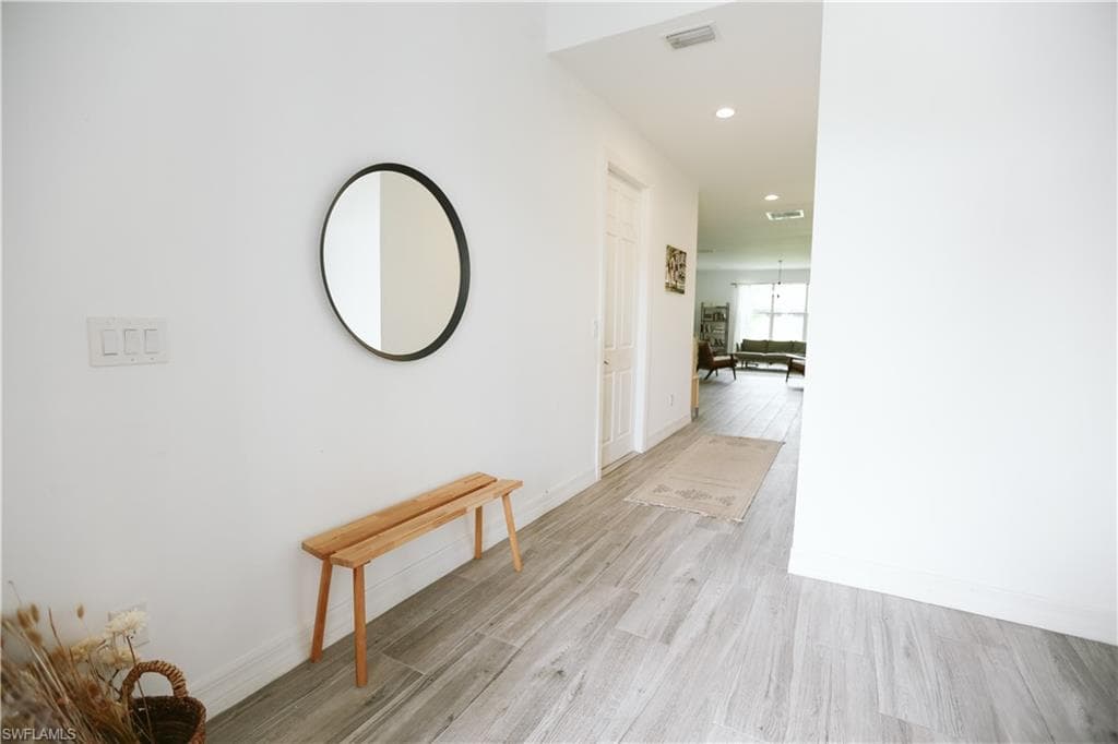 Corridor featuring light wood-style floors, recessed lighting, and baseboards