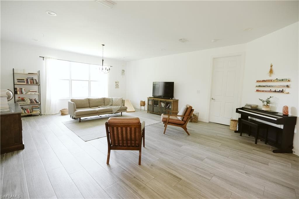Living area featuring a chandelier and light wood-style floors