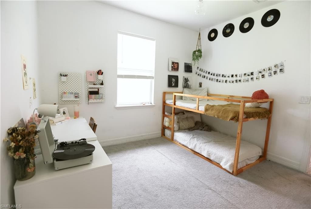 Bedroom featuring carpet, baseboards, and an office area