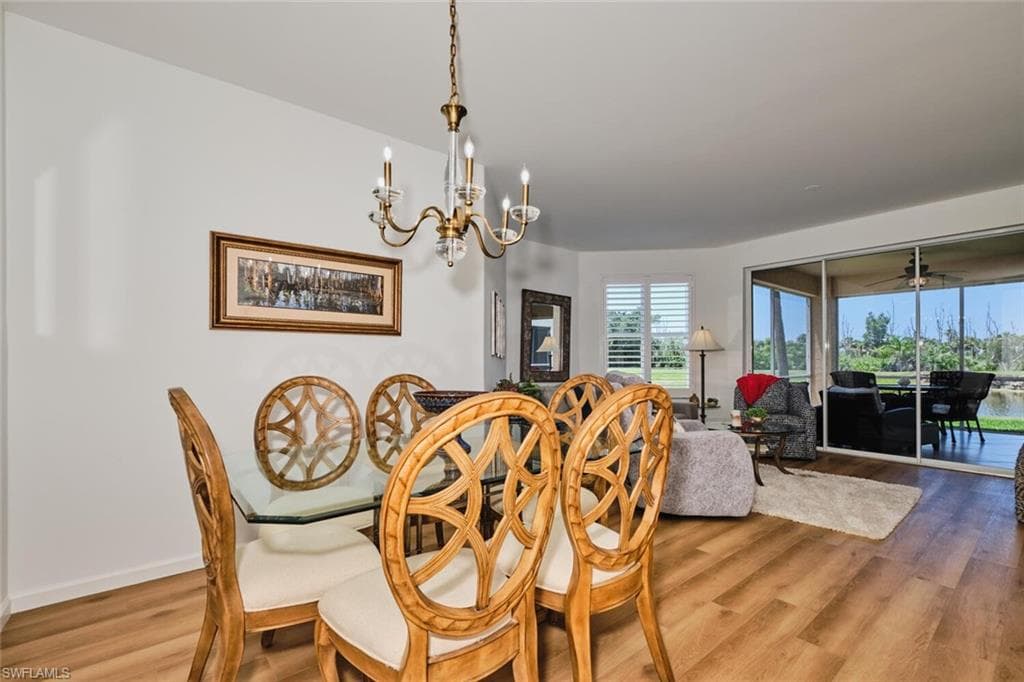 Dining space featuring wood finished floors and a chandelier