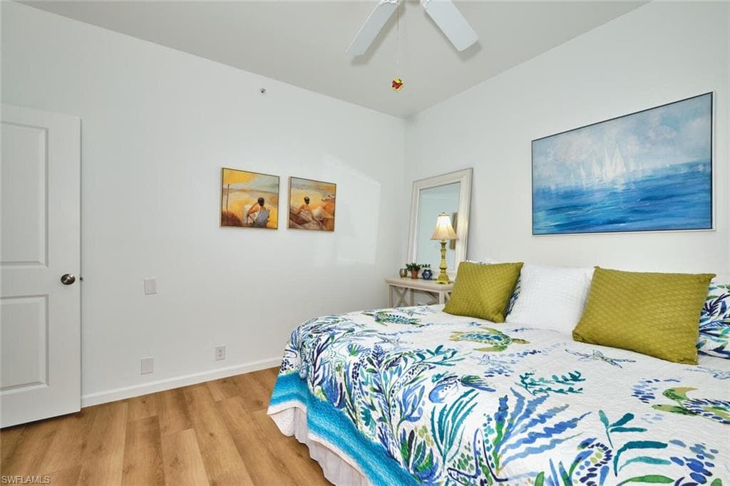 Bedroom with light wood-type flooring, ceiling fan, and baseboards