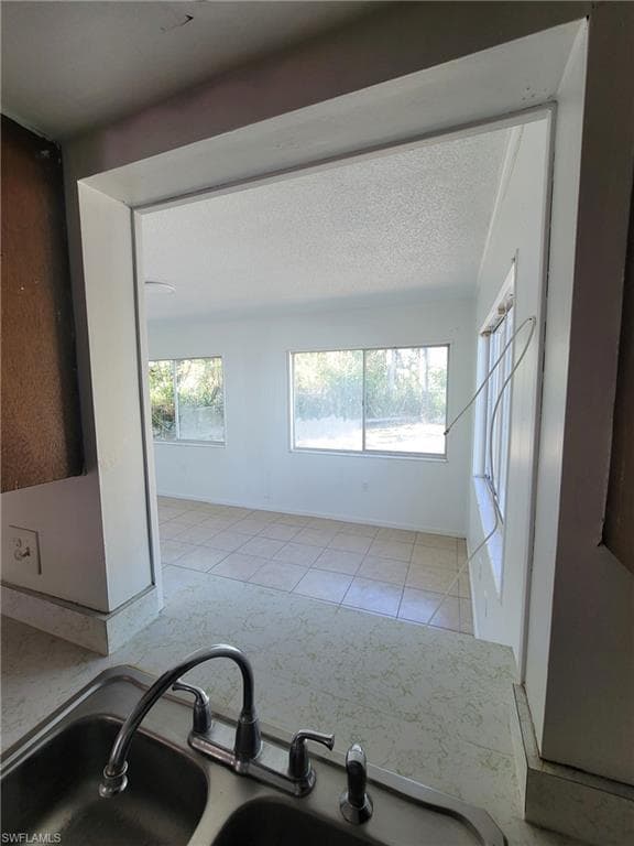 Kitchen featuring a textured ceiling and light tile patterned floors