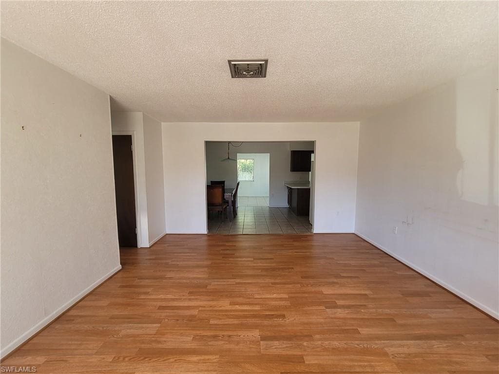 Spare room featuring a textured ceiling and light wood-style flooring