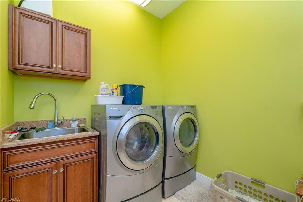 Laundry area featuring build in cabinets, washing machine and dryer