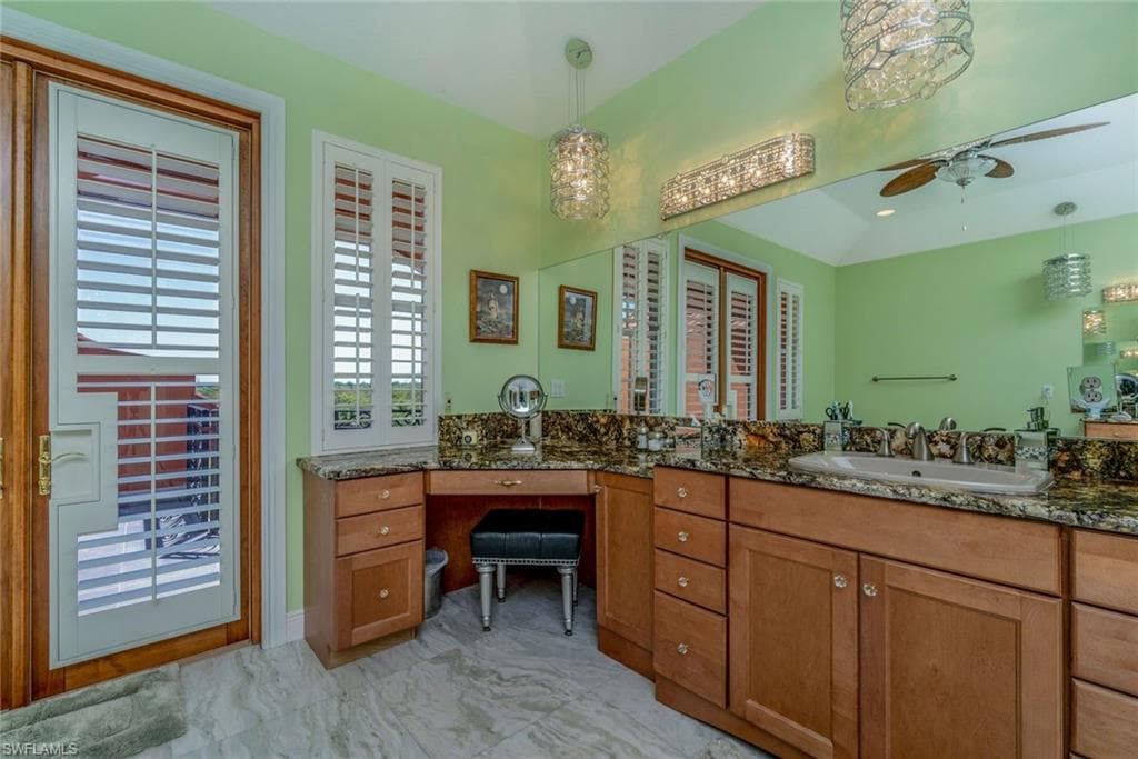 Master bathroom upstairs with double vanities, sinks, jetted tub, rain shower, specialty crystal lighting, Onxy flooring, ceiling fans and balcony