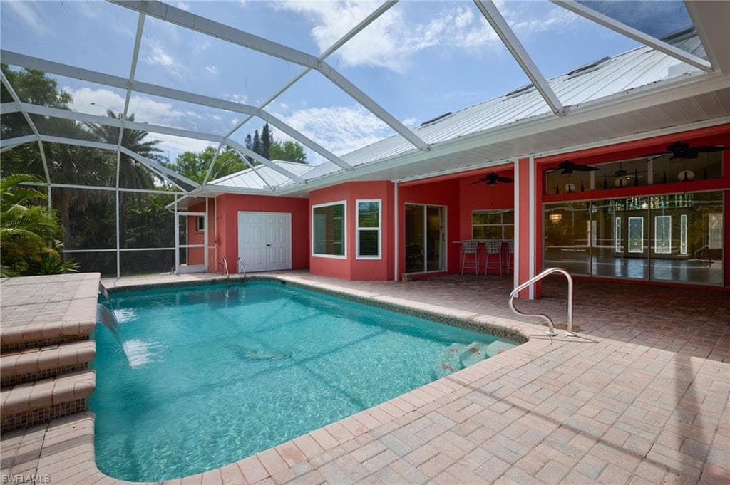 Swimming pool with a patio, a ceiling fan, and a lanai
