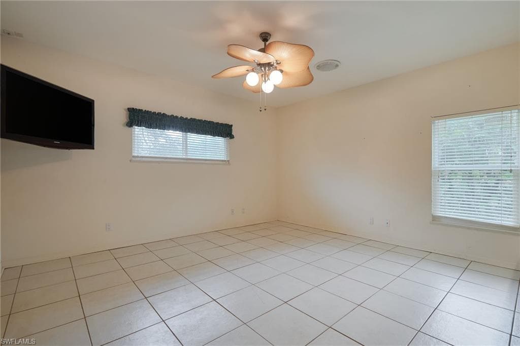 Unfurnished room featuring a ceiling fan and light tile patterned flooring