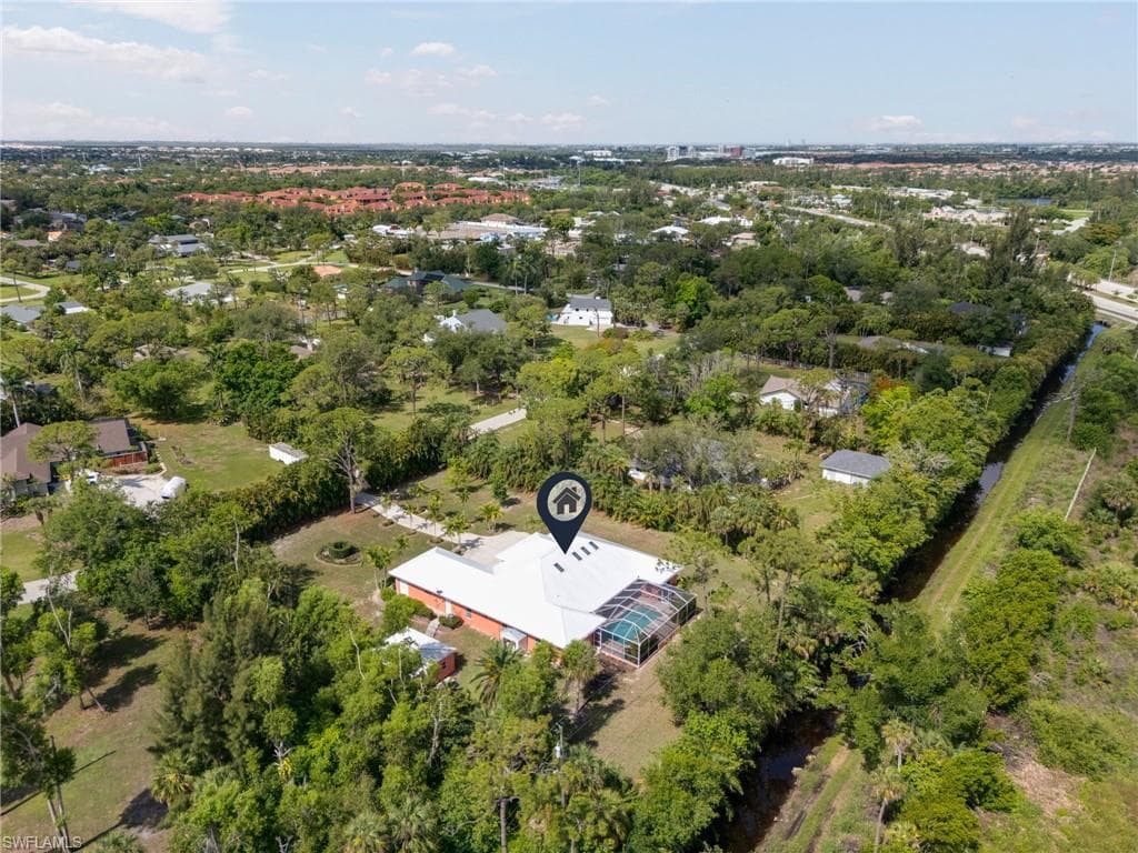 Aerial view of property's location with a tree filled landscape