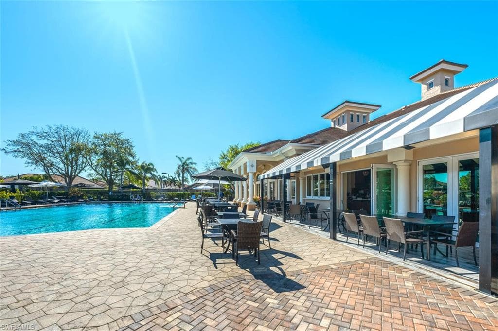 Community pool with a patio and outdoor dining space