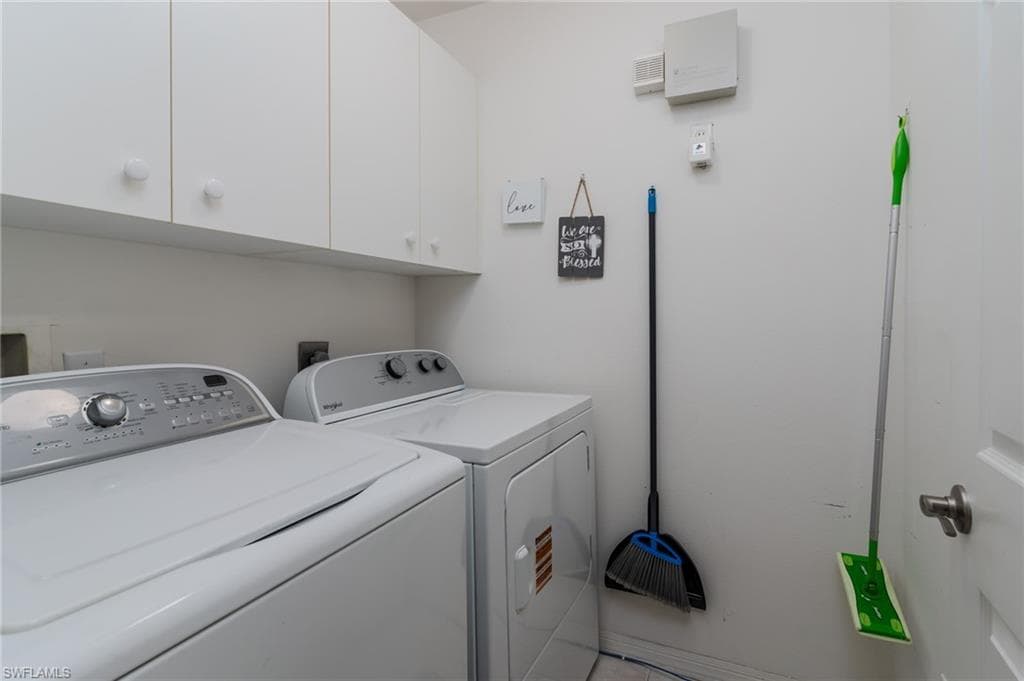 Laundry room featuring independent washer and dryer and cabinet space