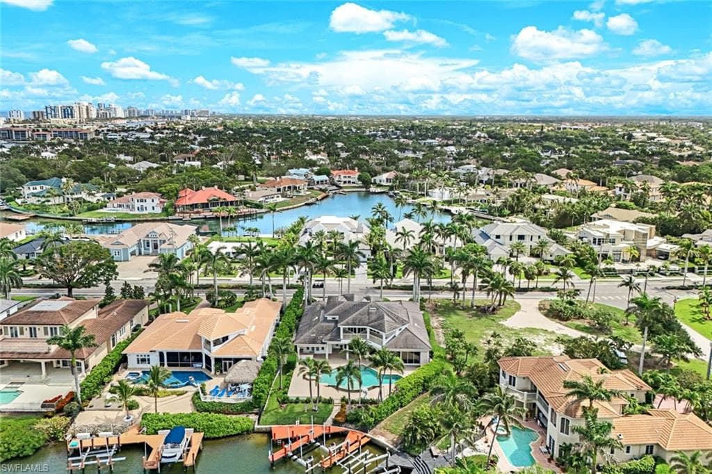 Aerial perspective of suburban area featuring a large body of water and a pool area