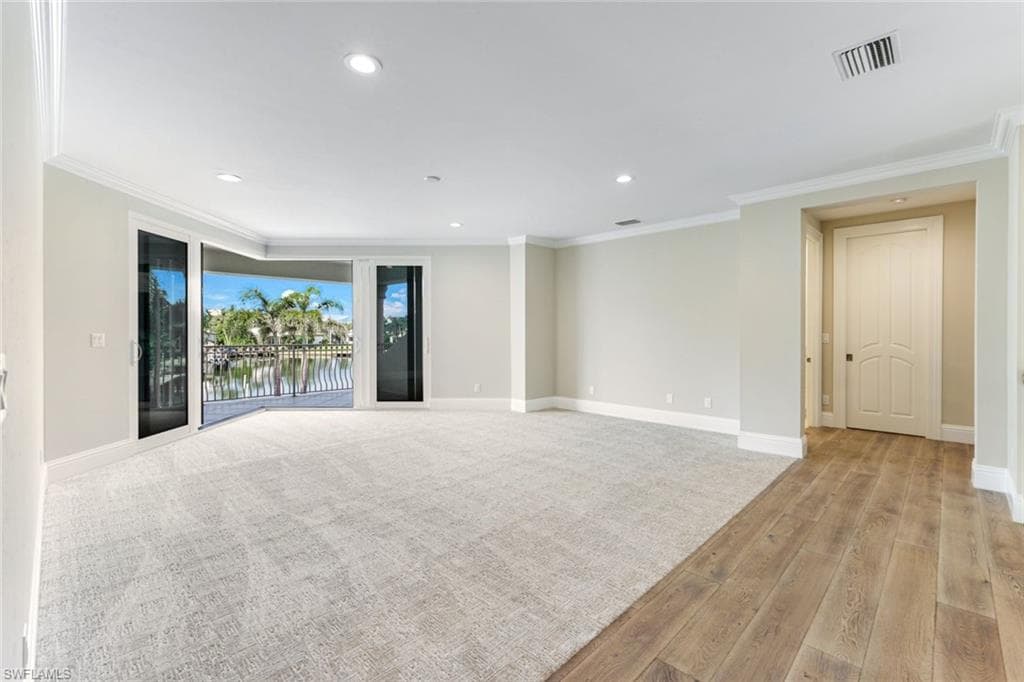 Upstairs Bonus Room with wrap around balcony, light wood finished floors, crown molding, and recessed lighting