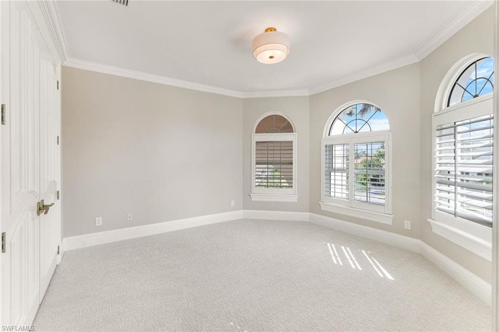 Bedroom #4 featuring ornamental molding and light colored carpet