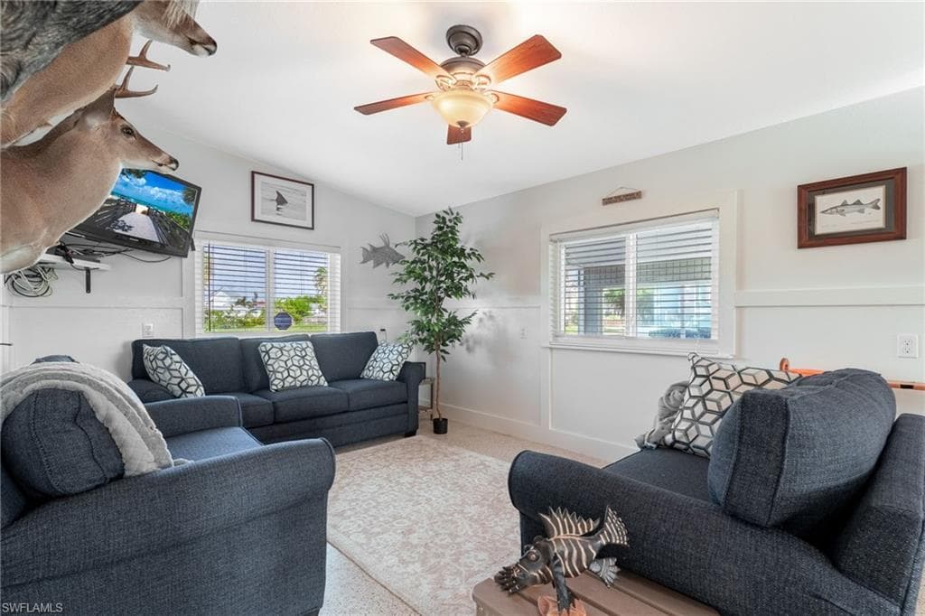 Living area with healthy amount of natural light, lofted ceiling, and ceiling fan