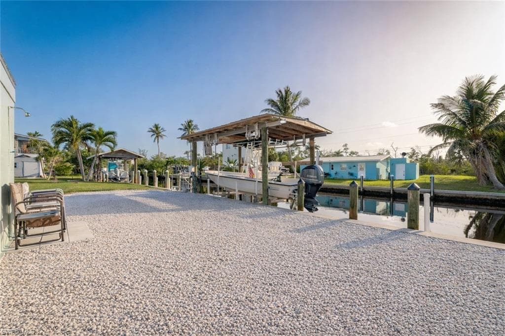 View of community featuring a dock, a water view, and boat lift