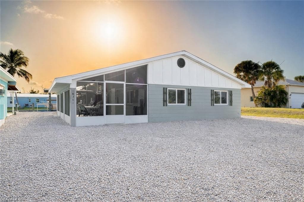 Back of house featuring a sunroom and board and batten siding
