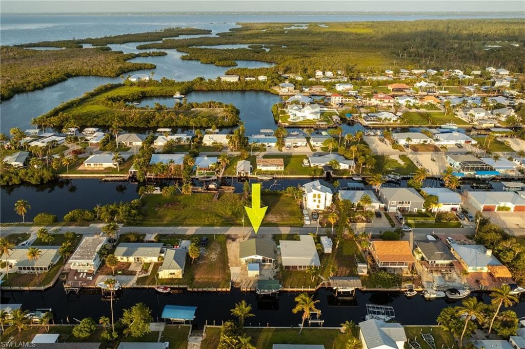 Aerial view of property and surrounding area with a nearby body of water and nearby suburban area