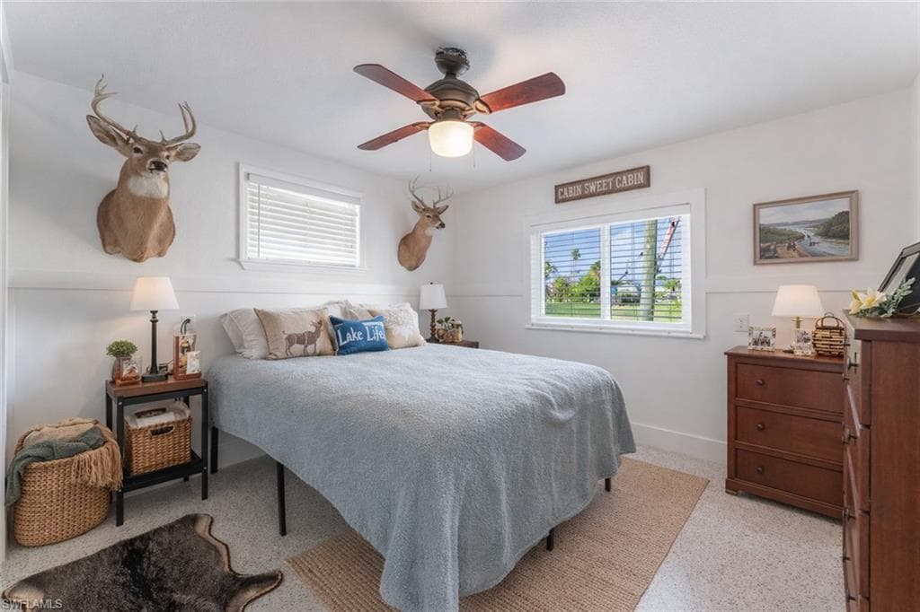 Bedroom with a ceiling fan and dark speckled floor