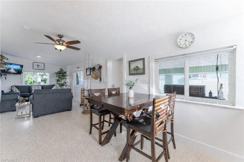 Dining area featuring a ceiling fan and dark speckled floor