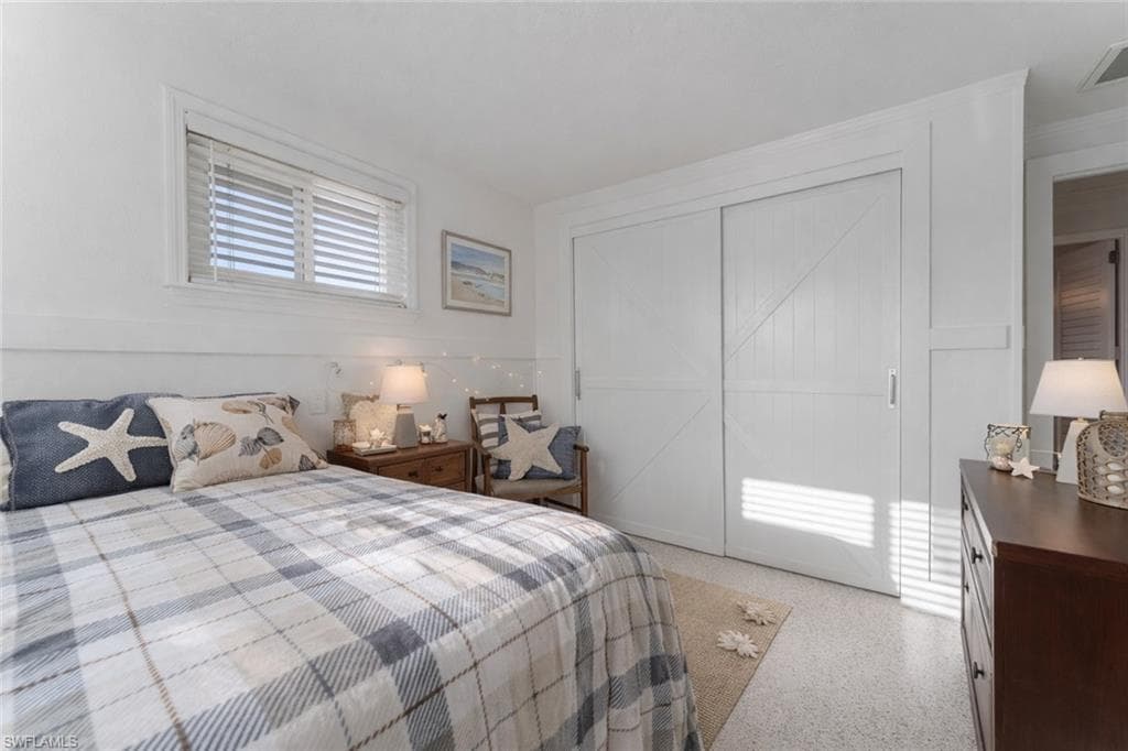 Bedroom with a closet and dark aggregate flooring