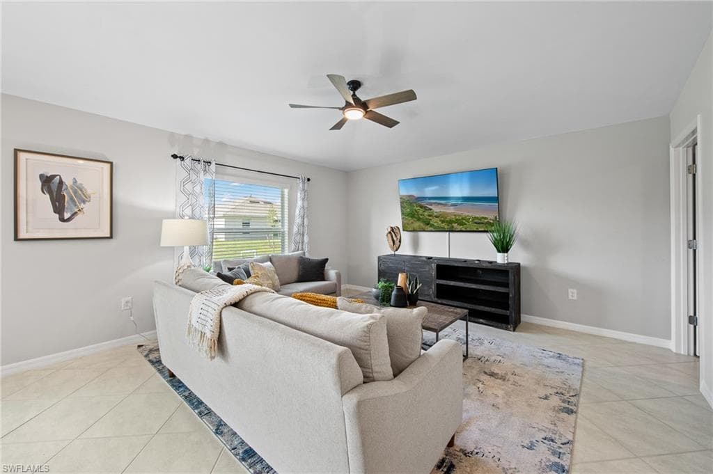 Living area with light tile patterned floors and ceiling fan
