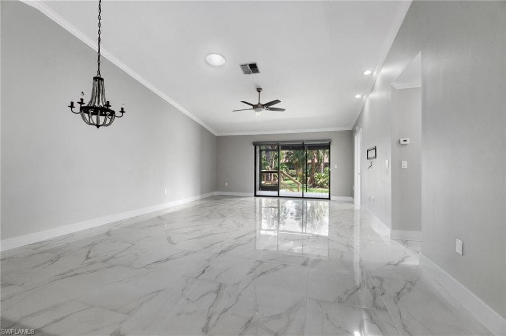Empty room featuring crown molding, a ceiling fan, light marble finish floors, a chandelier, and recessed lighting