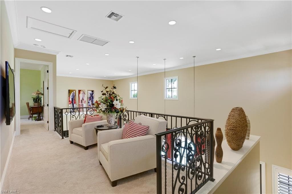 Hall featuring ornamental molding, light carpet, recessed lighting, and an upstairs landing