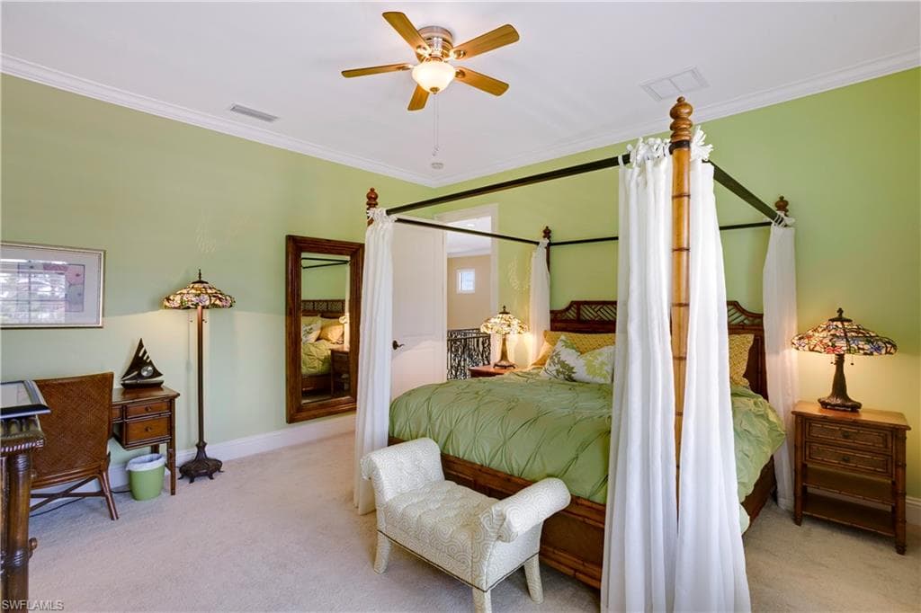 Bedroom featuring carpet floors, crown molding, and ceiling fan