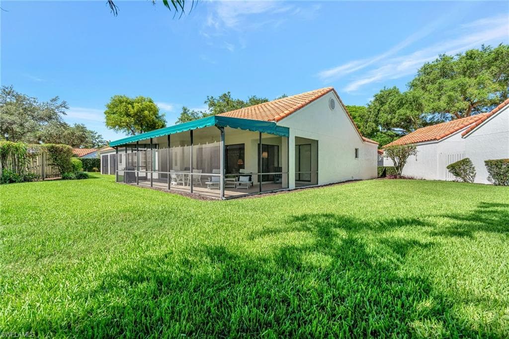 Rear view of property featuring a tiled roof and stucco siding