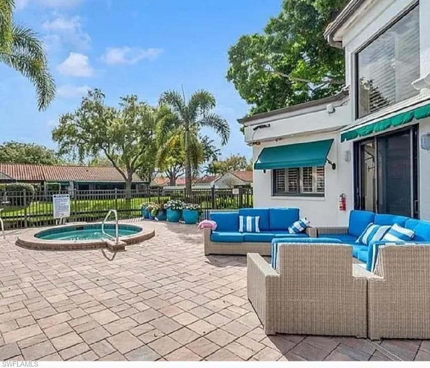 View of patio featuring a community hot tub and an outdoor living space