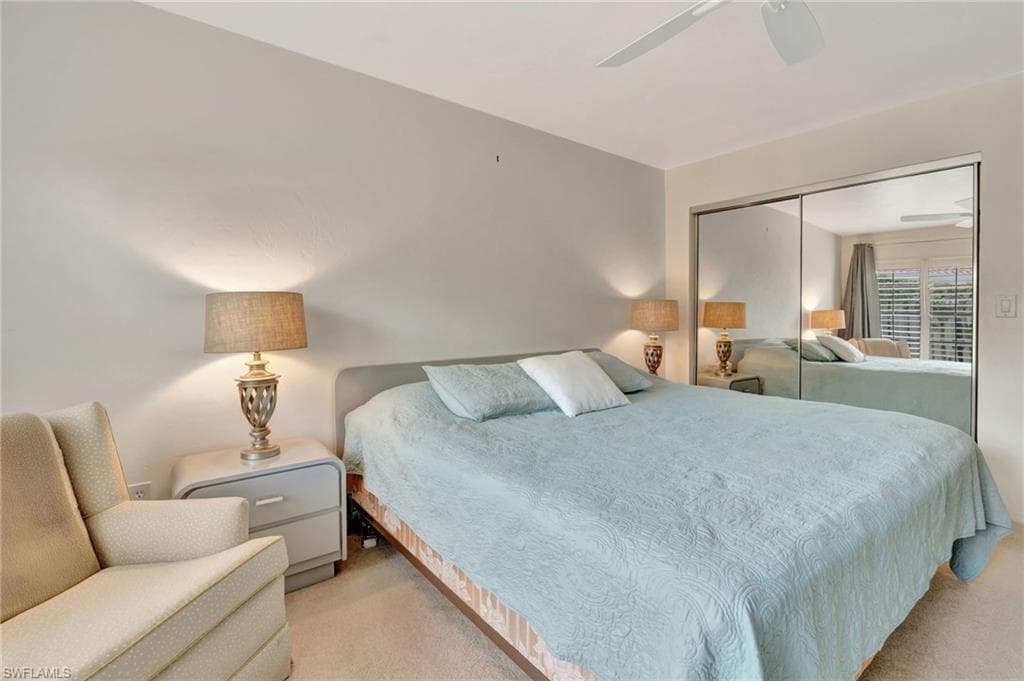 Carpeted bedroom with a closet and ceiling fan